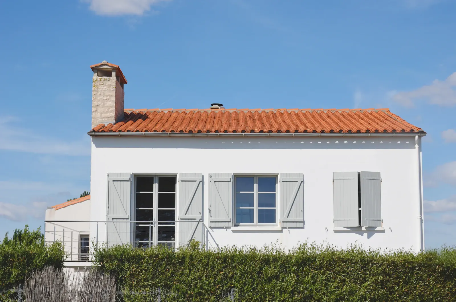 Casa blanca con tejado de teja y contraventanas