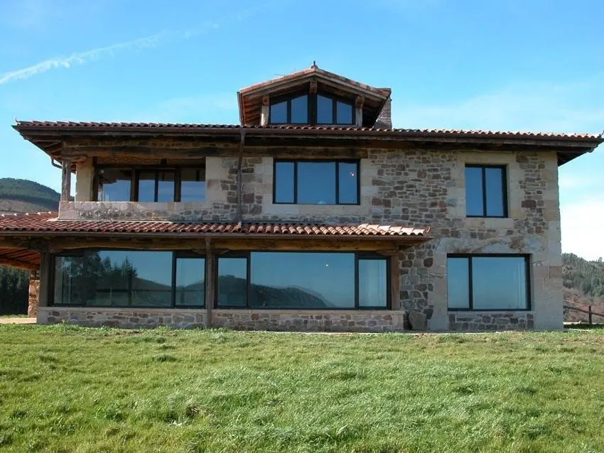 Casa de piedra con grandes ventanales