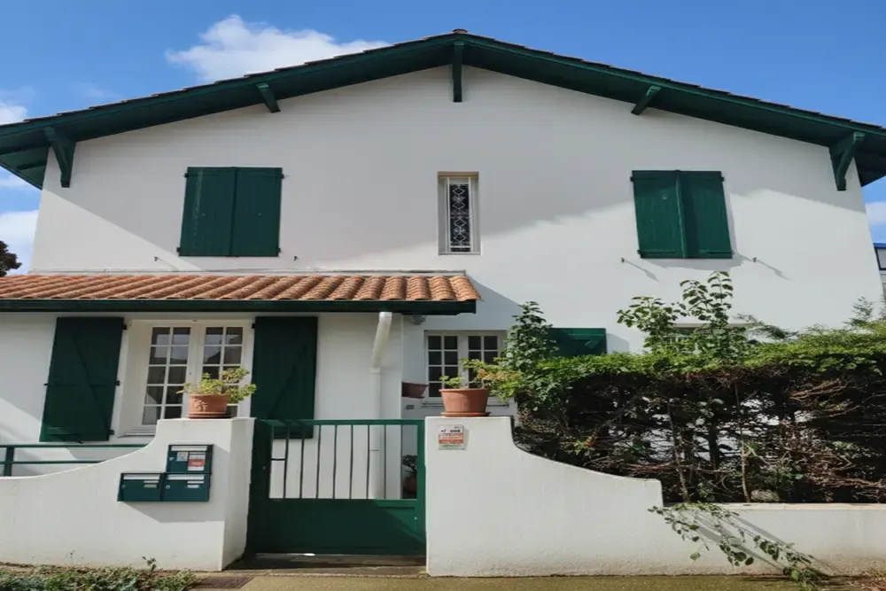 Casa vasca con fachada blanca y contraventanas verdes