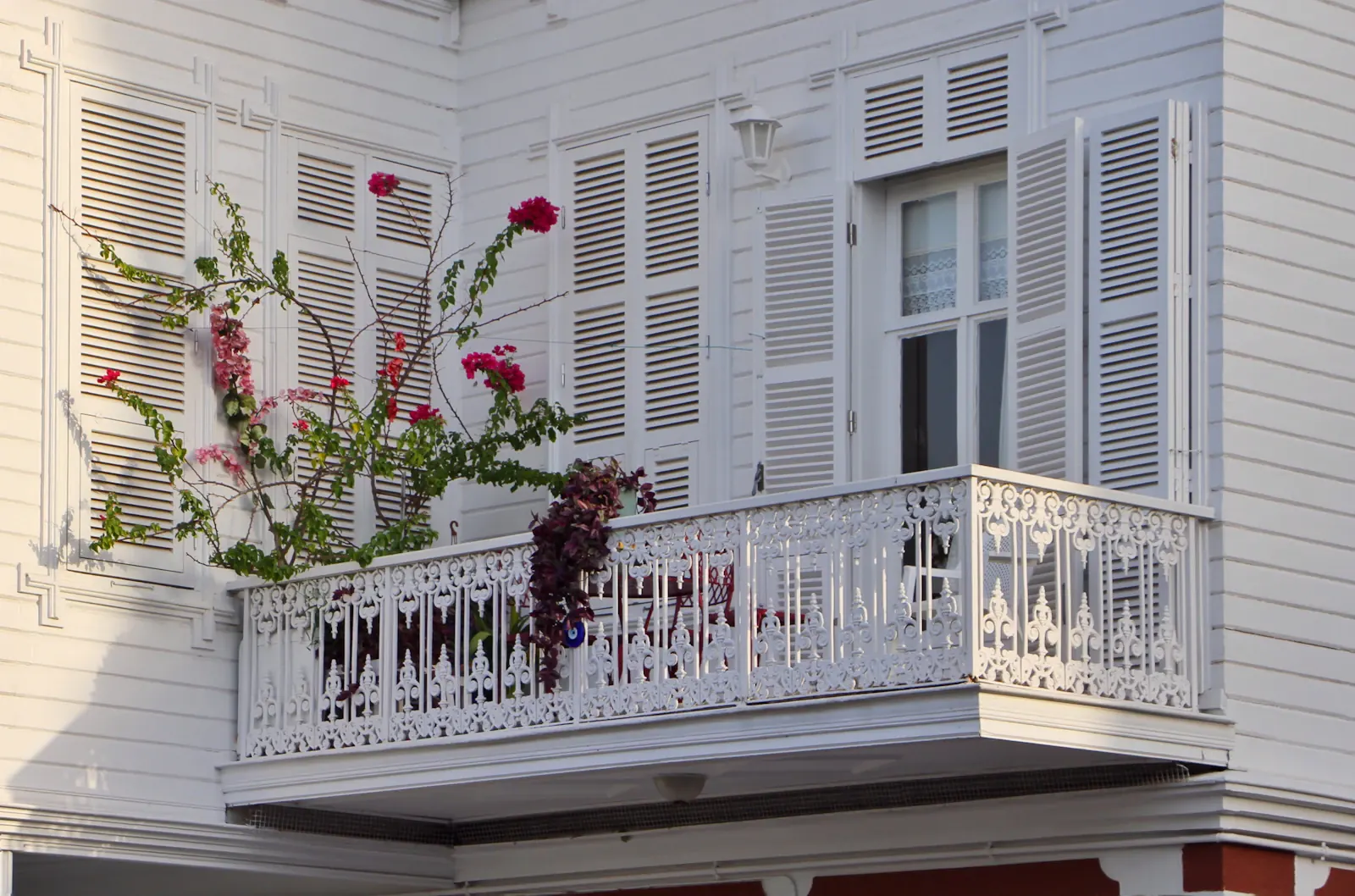 Fachada blanca con balcón y contraventanas