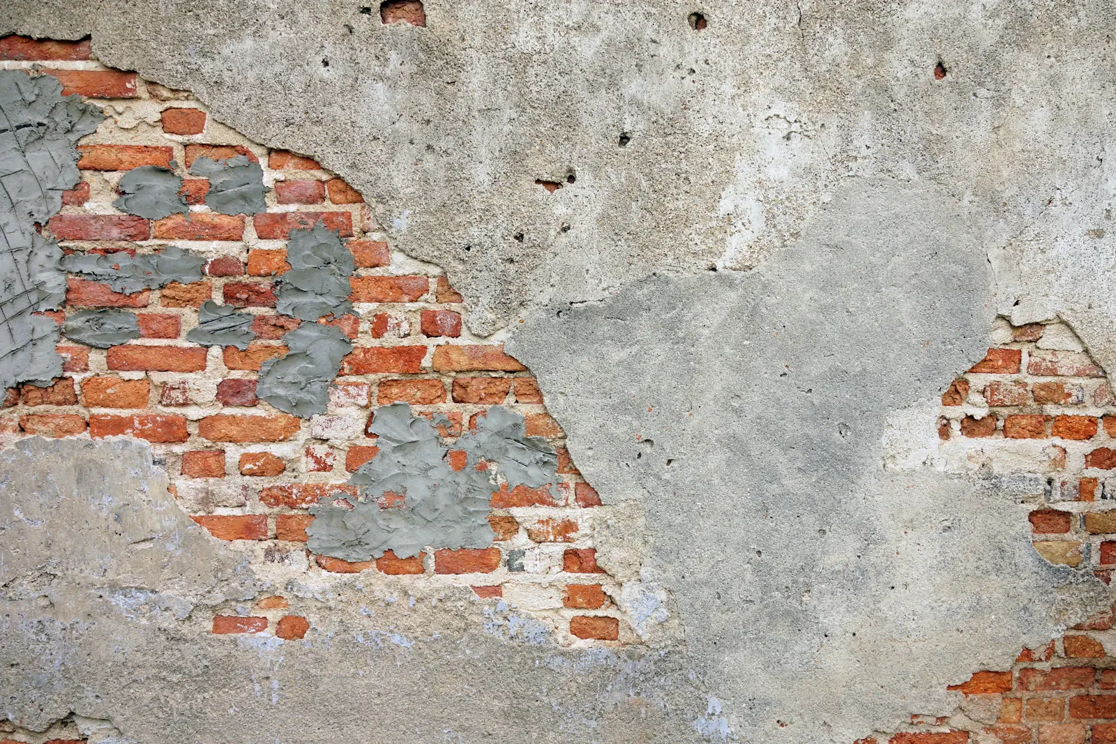 Enduit de façade décollé sur un mur en briques