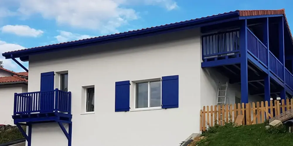 Vivienda blanca con balcón azul